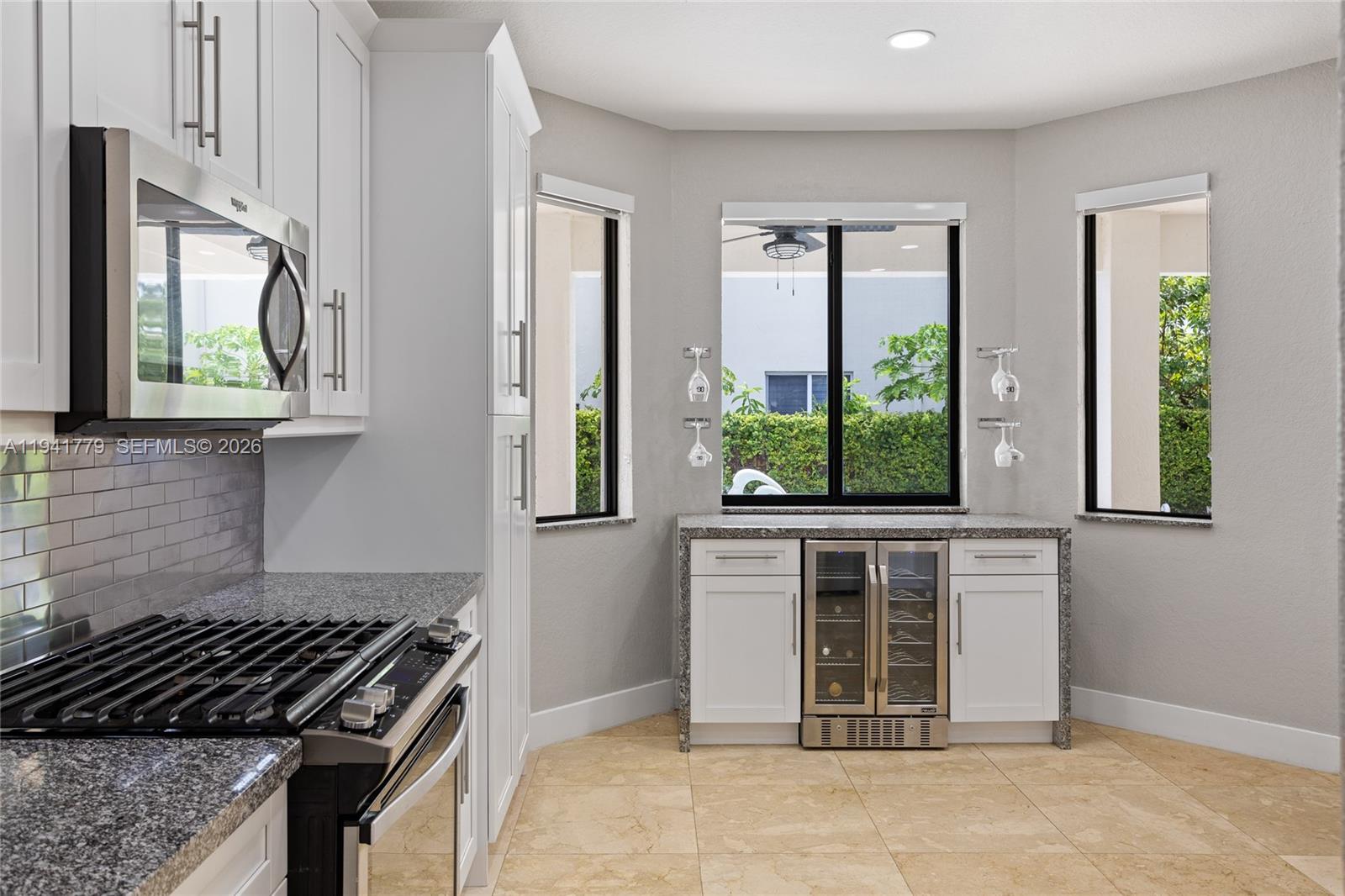 5324 Southwest 164th Court Miami, FL 33185 - Photo 23 of 47 a kitchen with stainless steel appliances a stove and a white cabinet next to a window