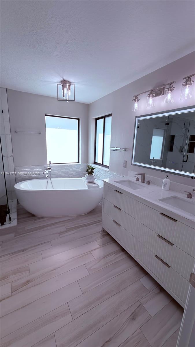 5324 Southwest 164th Court Miami, FL 33185 - Photo 36 of 47 a spacious bathroom with a double vanity sink a mirror and a bathtub