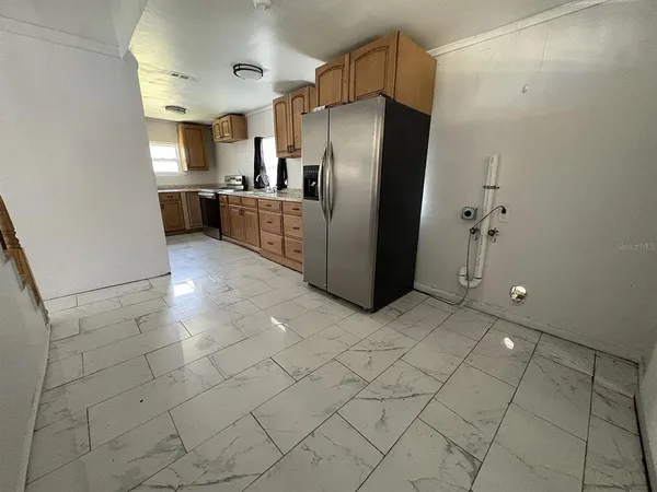 a kitchen with granite countertop a refrigerator and a stove top oven