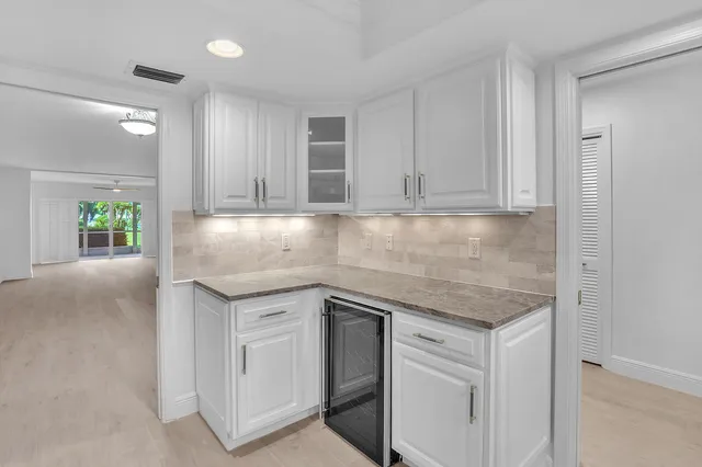 a kitchen with granite countertop white cabinets and a sink