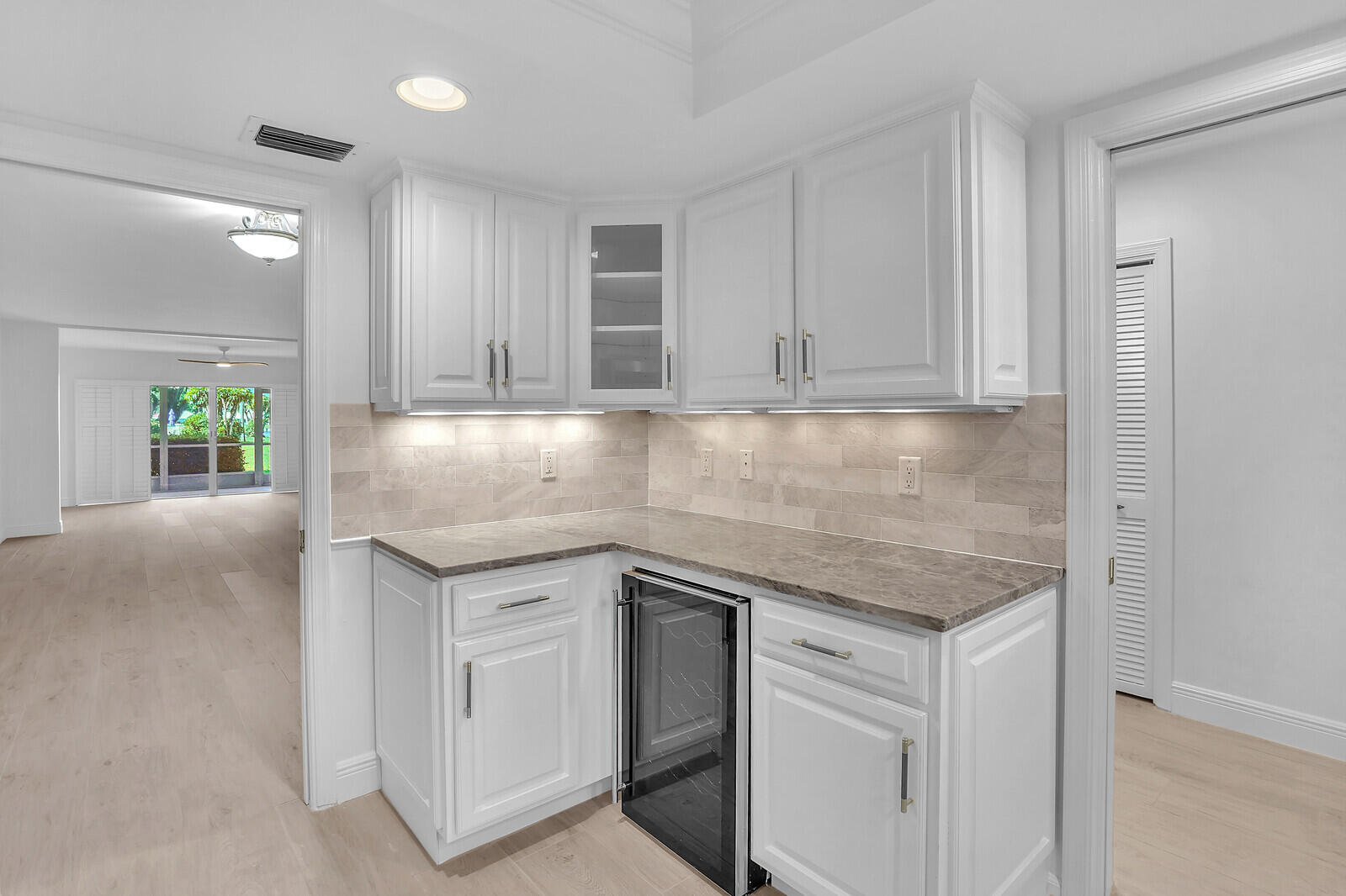 a kitchen with granite countertop white cabinets and a sink