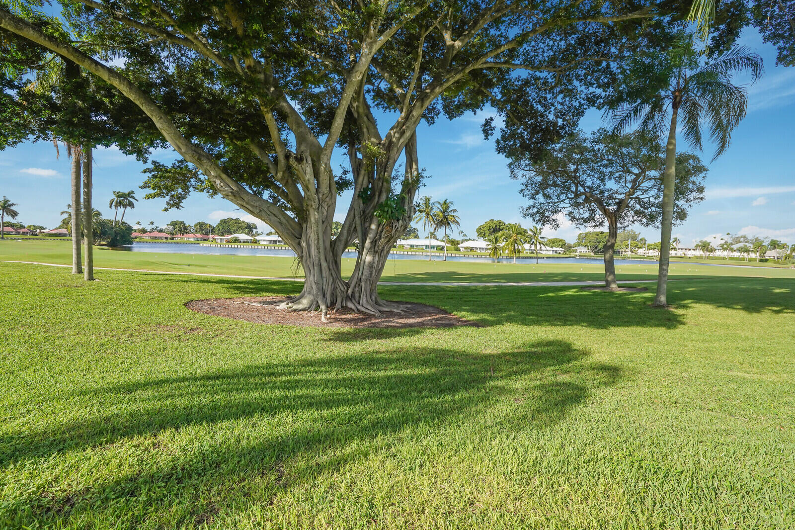 145 Atlantis Boulevard, Unit 104 Atlantis, FL 33462 - Photo 2 of 49 a view of a park with large trees