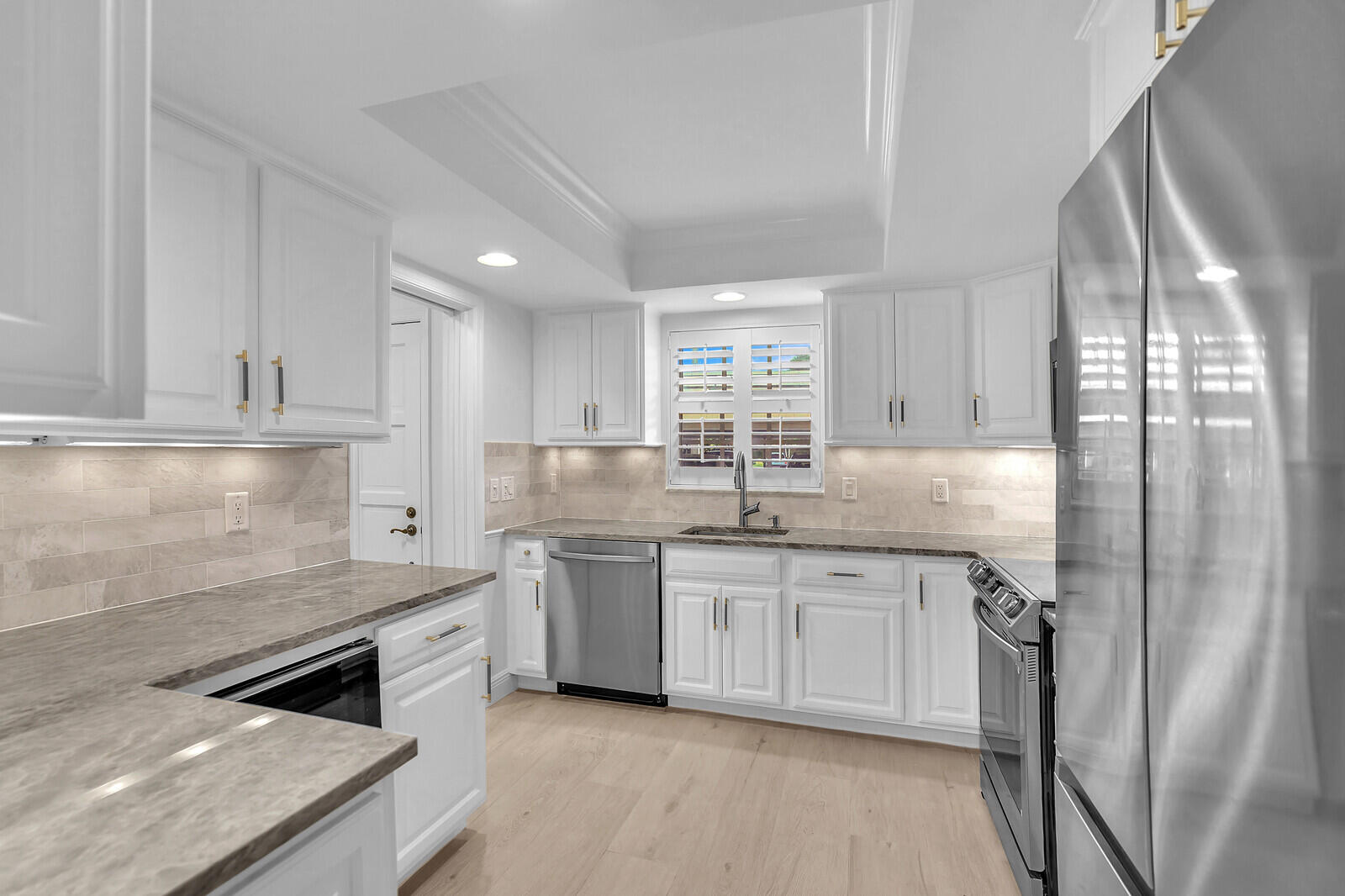 145 Atlantis Boulevard, Unit 104 Atlantis, FL 33462 - Photo 22 of 49 a kitchen with stainless steel appliances granite countertop a stove sink and cabinets