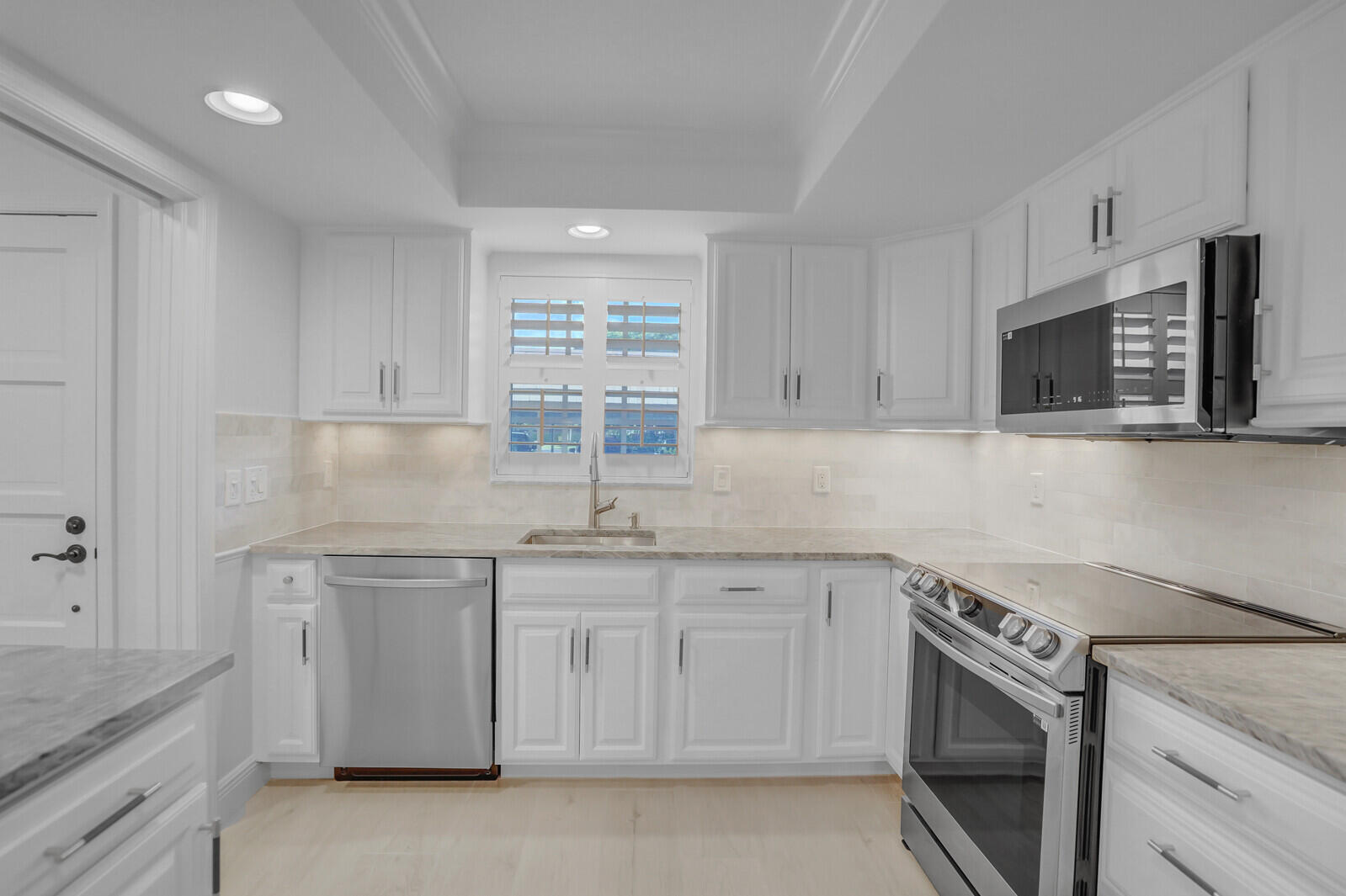 145 Atlantis Boulevard, Unit 104 Atlantis, FL 33462 - Photo 23 of 49 a kitchen with cabinets appliances a sink and a counter top space