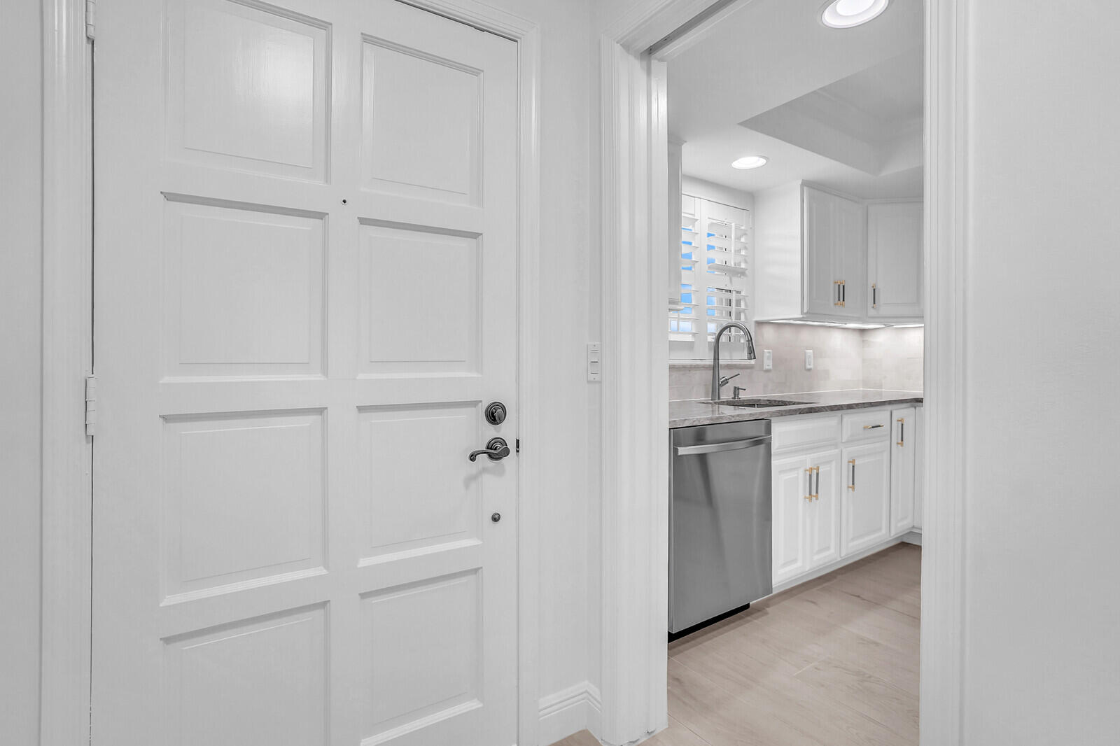 145 Atlantis Boulevard, Unit 104 Atlantis, FL 33462 - Photo 3 of 49 a kitchen with white cabinets and white appliances