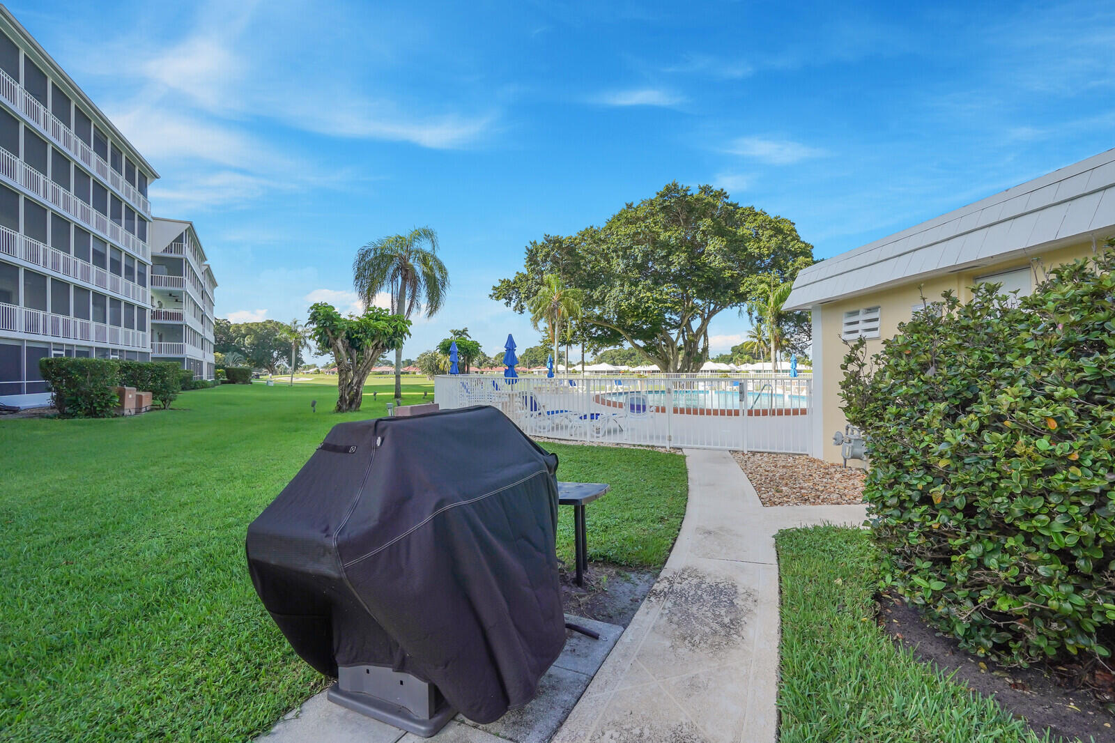 145 Atlantis Boulevard, Unit 104 Atlantis, FL 33462 - Photo 41 of 49 a view of yard with swimming pool and green space