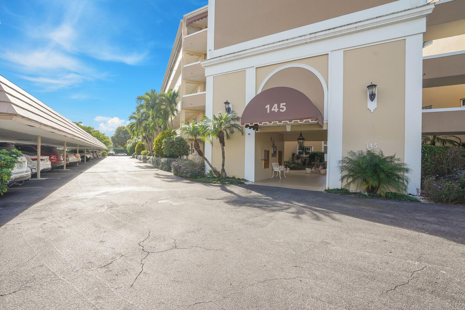 145 Atlantis Boulevard, Unit 104 Atlantis, FL 33462 - Photo 49 of 49 a view of a grey house with a yard