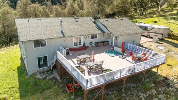 an aerial view of a house with swimming pool and large trees