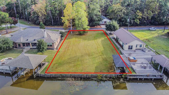 an aerial view of a house with swimming pool and large trees