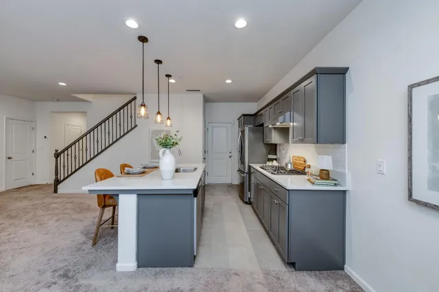 a kitchen with stainless steel appliances kitchen island granite countertop a table and chairs in it