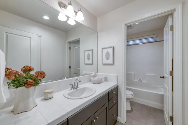 a bathroom with a granite countertop sink a large mirror and a bathtub