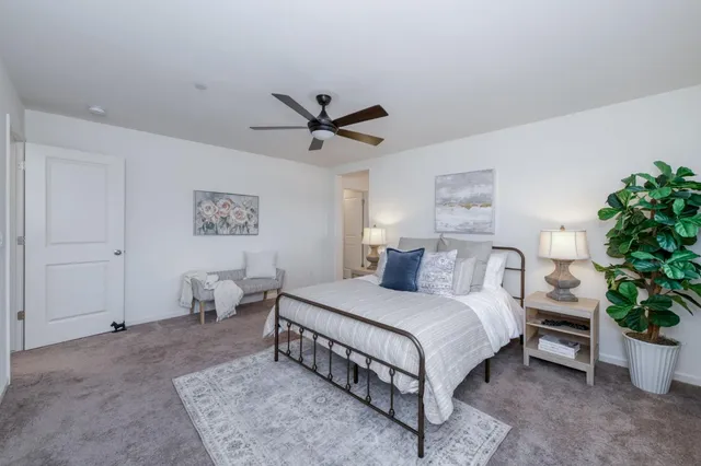 a bedroom with a large bed and a chandelier