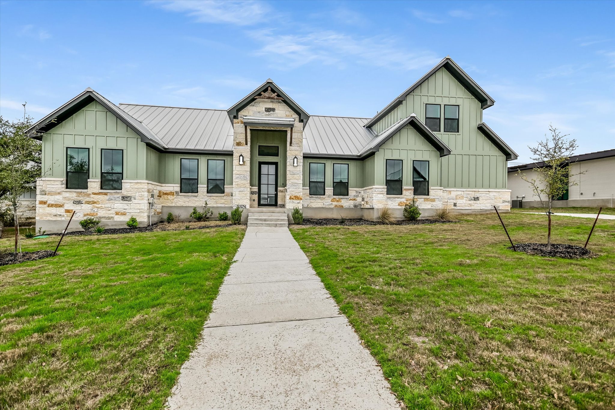 32 Peace Pipe Wimberley, TX 78676 - Photo 1 of 20 Modern farmhouse featuring board and batten siding, stone siding, a standing seam roof, and a front yard