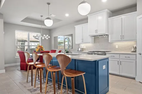 a large kitchen with cabinets a sink dining table and chairs