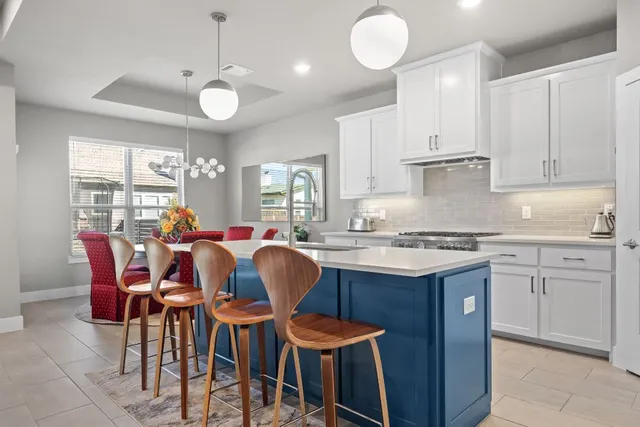 a large kitchen with cabinets a sink dining table and chairs