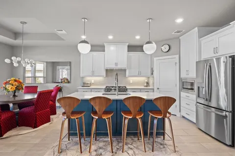 a kitchen with granite countertop stainless steel appliances white cabinets and refrigerator