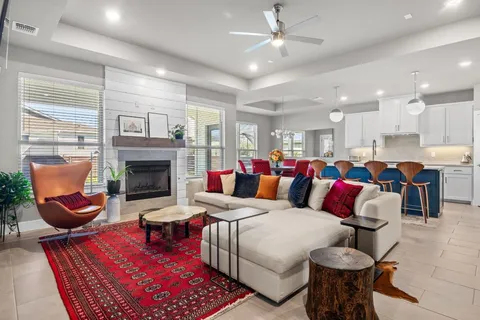 a living room with furniture a fireplace and a chandelier