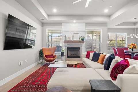 a living room with furniture a flat screen tv and a fireplace