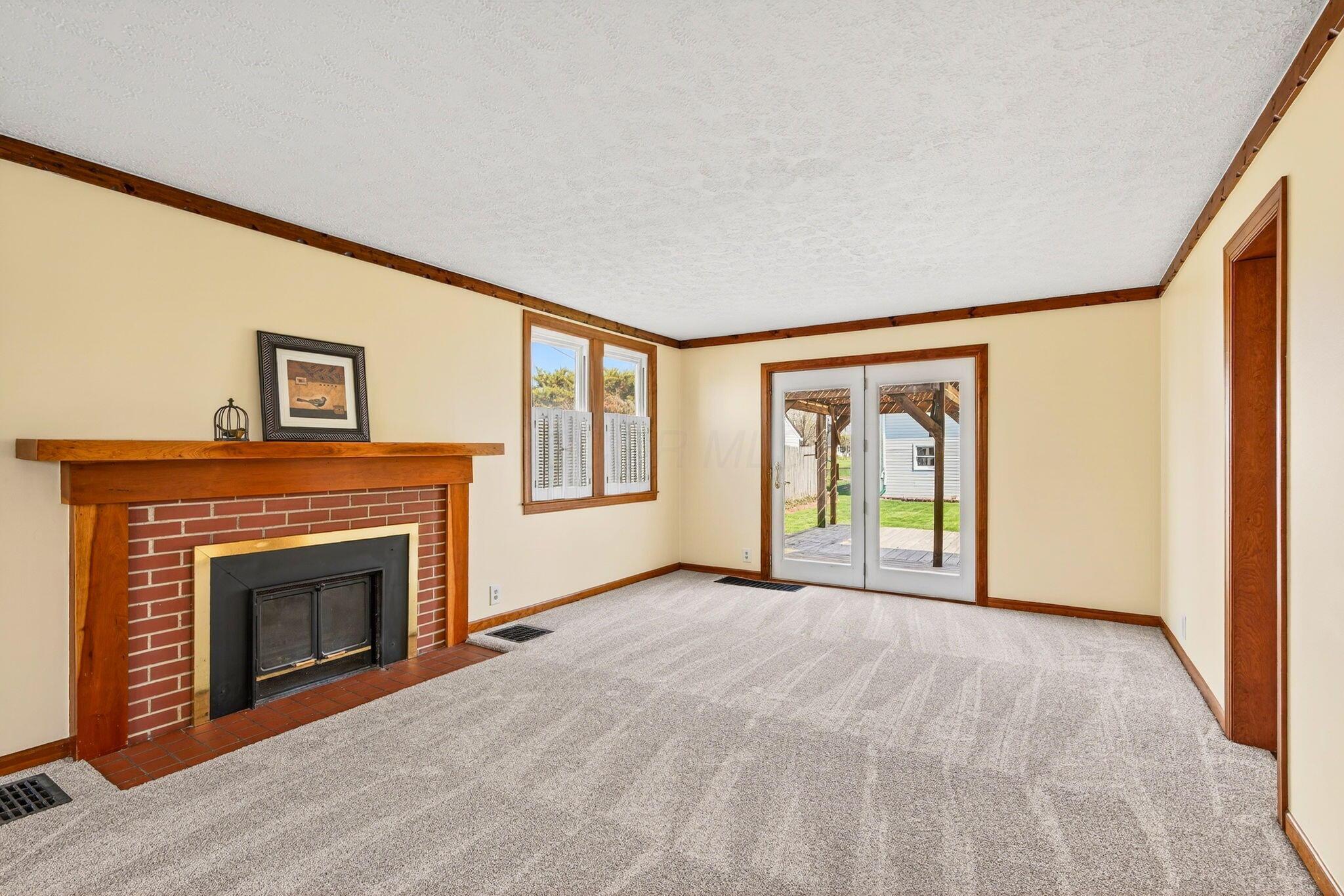 892 North Court Street Circleville, OH 43113 - Photo 16 of 58 Large living space with charming shutters. Patio door leading to the outside living space, as well as a woodburning fireplace! There is hardwood under the carpeting if you're interested!