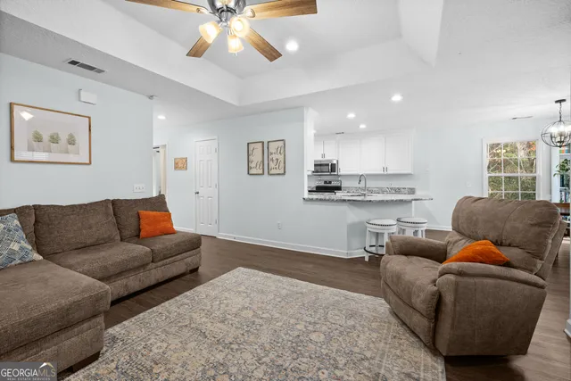 a living room with furniture and a view of kitchen