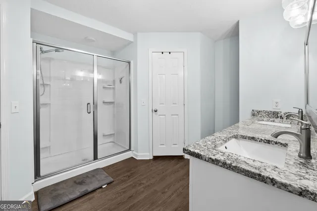 a bathroom with a granite countertop sink and shower