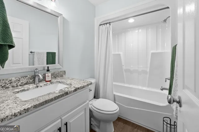 a bathroom with a granite countertop sink toilet and shower