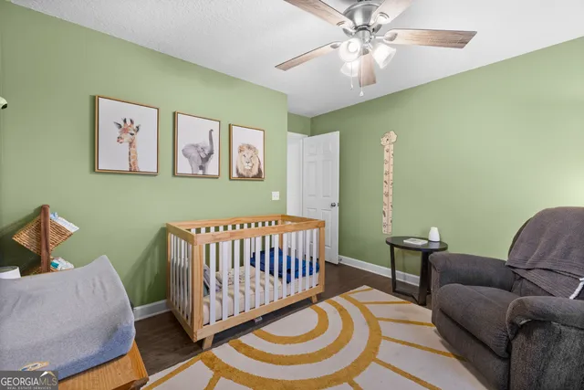 a living room with furniture and a baby crib