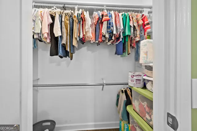a view of walk in closet with clothes and shoes