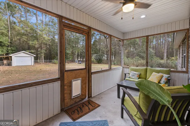 a living room with furniture and a floor to ceiling window