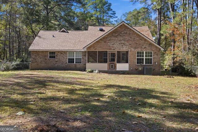 a front view of house with yard and trees around