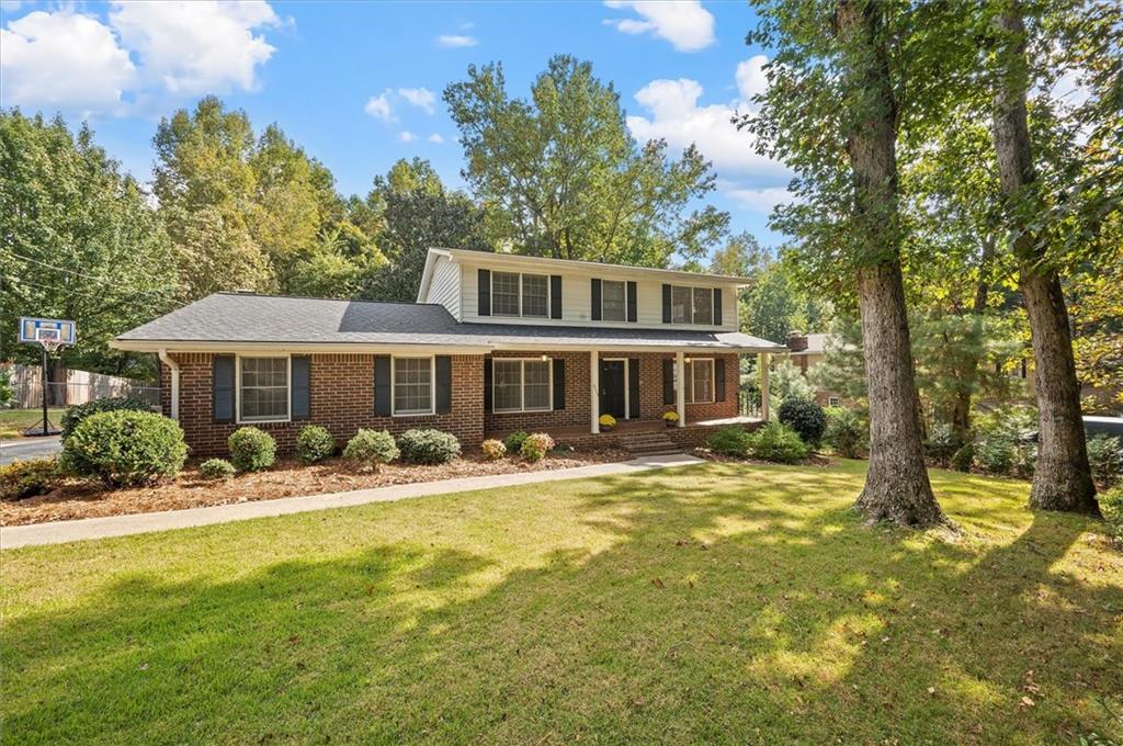 5115 Tilly Mill Road Dunwoody, GA 30338 - Photo 1 of 1 a front view of a house with a yard table and chairs