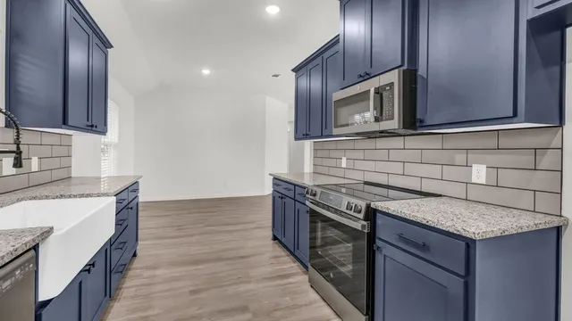 a kitchen with granite countertop stainless steel appliances and wooden cabinets