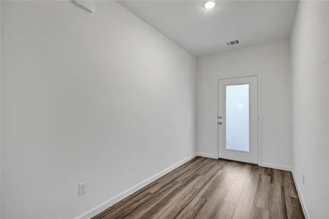 a view of an empty room and wooden floor
