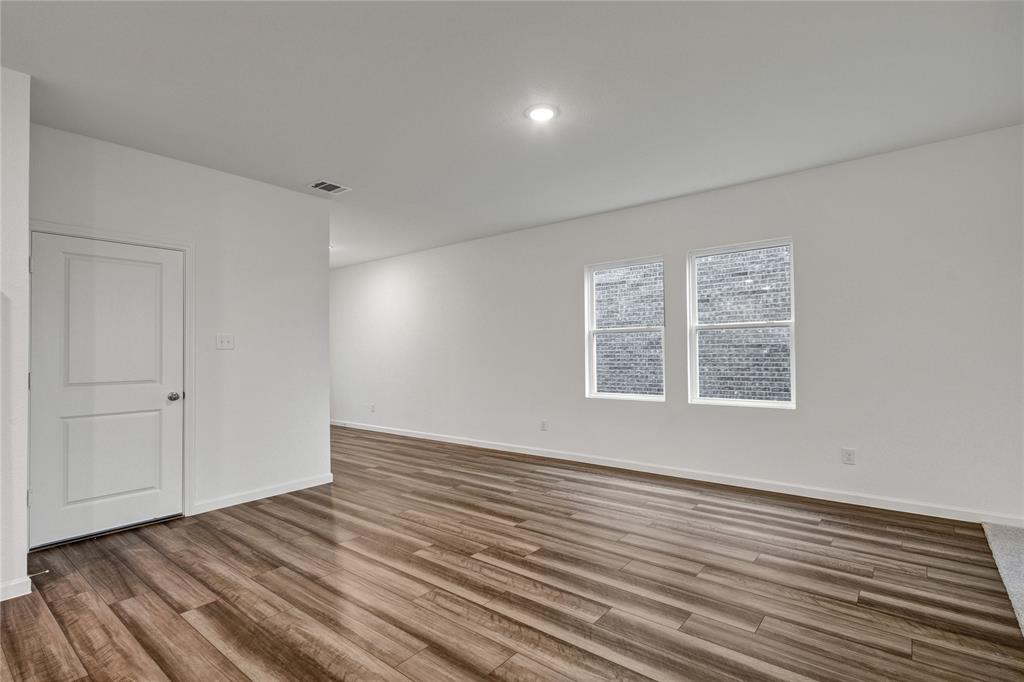 600 Merced River Lane Anna, TX 75409 - Photo 7 of 40 a view of an empty room with wooden floor and a window