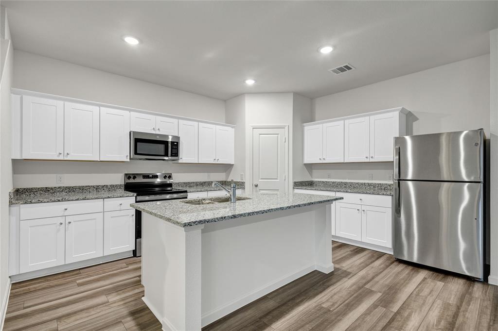 600 Merced River Lane Anna, TX 75409 - Photo 9 of 40 a kitchen with stainless steel appliances granite countertop a stove a sink and a refrigerator