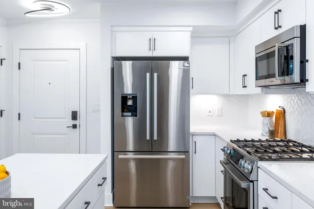 a kitchen with stainless steel appliances granite countertop a refrigerator stove and sink