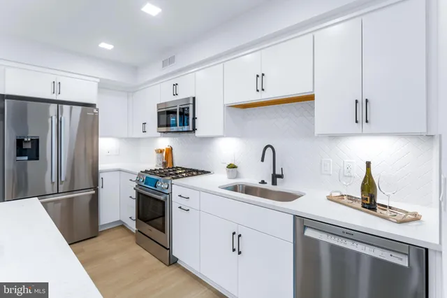a kitchen with cabinets stainless steel appliances and a sink