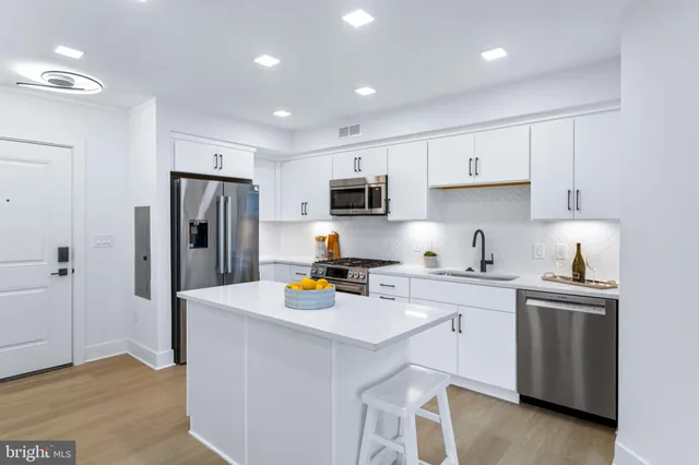 a kitchen with a refrigerator a microwave a sink and cabinets