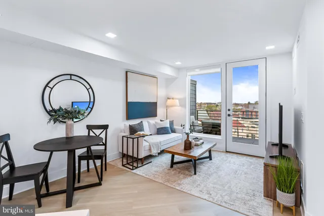 a living room with furniture a rug and a painting on the wall