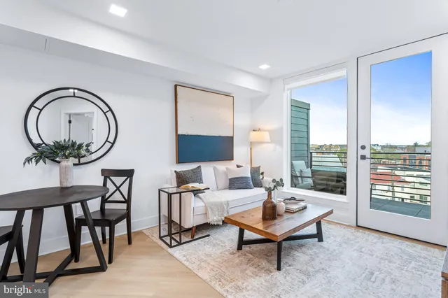 a living room with furniture a rug a lamp and a large window