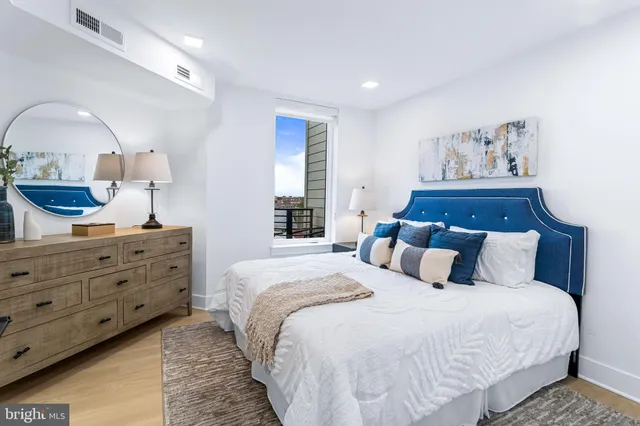 a bedroom with a large bed and a mirror on dresser