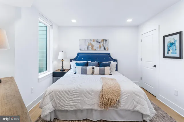 a bedroom with a bed and painting on the wall