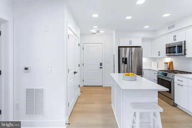 a kitchen with stainless steel appliances a refrigerator and a stove top oven