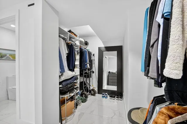 a view of walk in closet with clothes and shoes