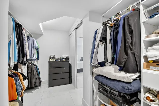a view of walk in closet with clothes and shoes