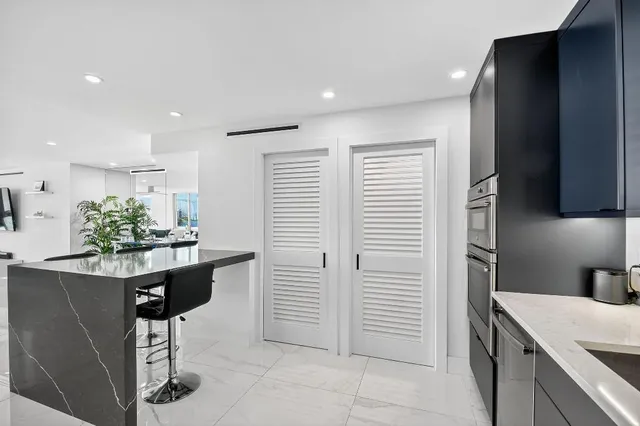 a kitchen with stainless steel appliances kitchen island granite countertop a refrigerator and a stove