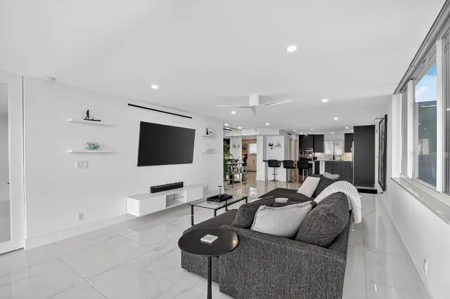 a living room with furniture kitchen view and a flat screen tv