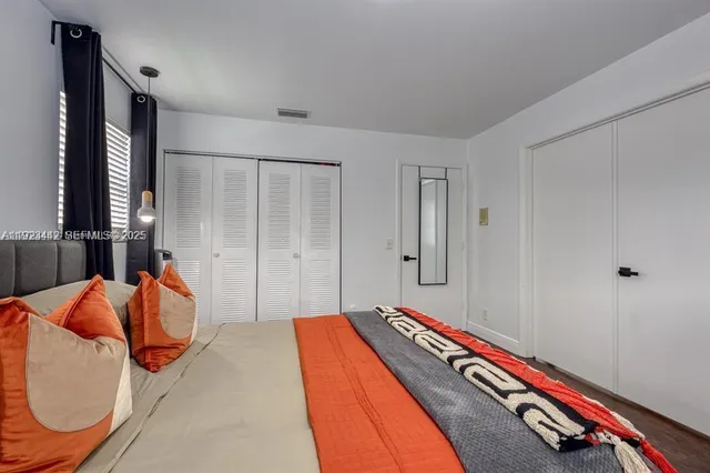 a bedroom with bed and wooden floor