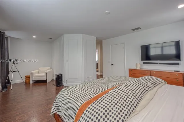 a bedroom with a bed and a flat screen tv