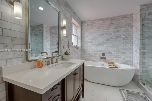 a bathroom with a tub a sink and mirror